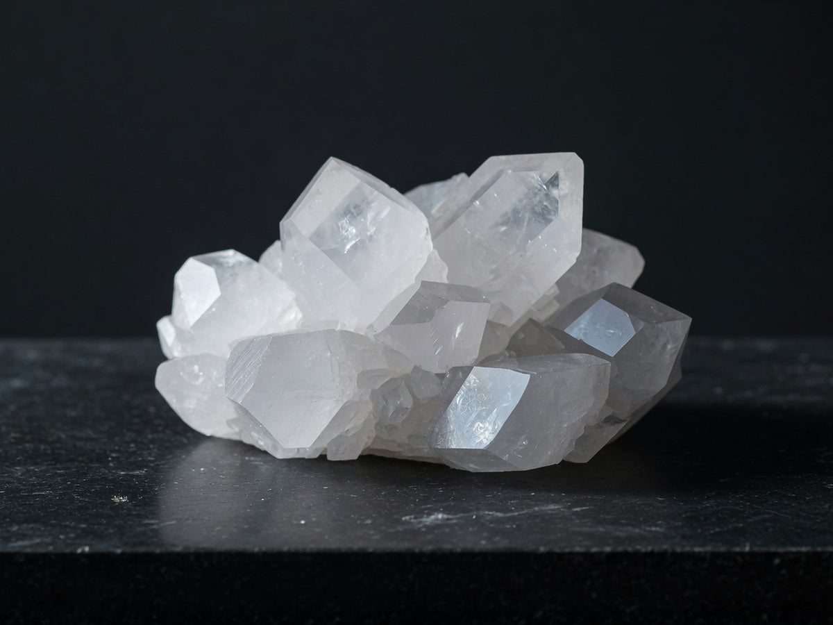 A cluster of translucent milky-white crystals with flat cleavage faces catching the light.