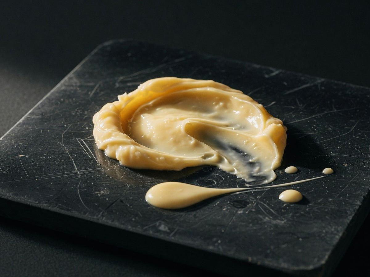 A dense pool of yellow-ivory first milk, viscous and slow.