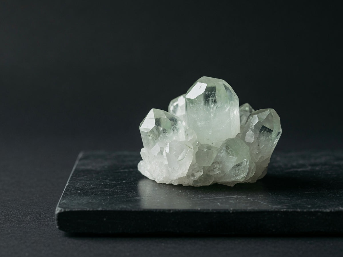 A cluster of pale green-white apatite crystals with hexagonal faces.