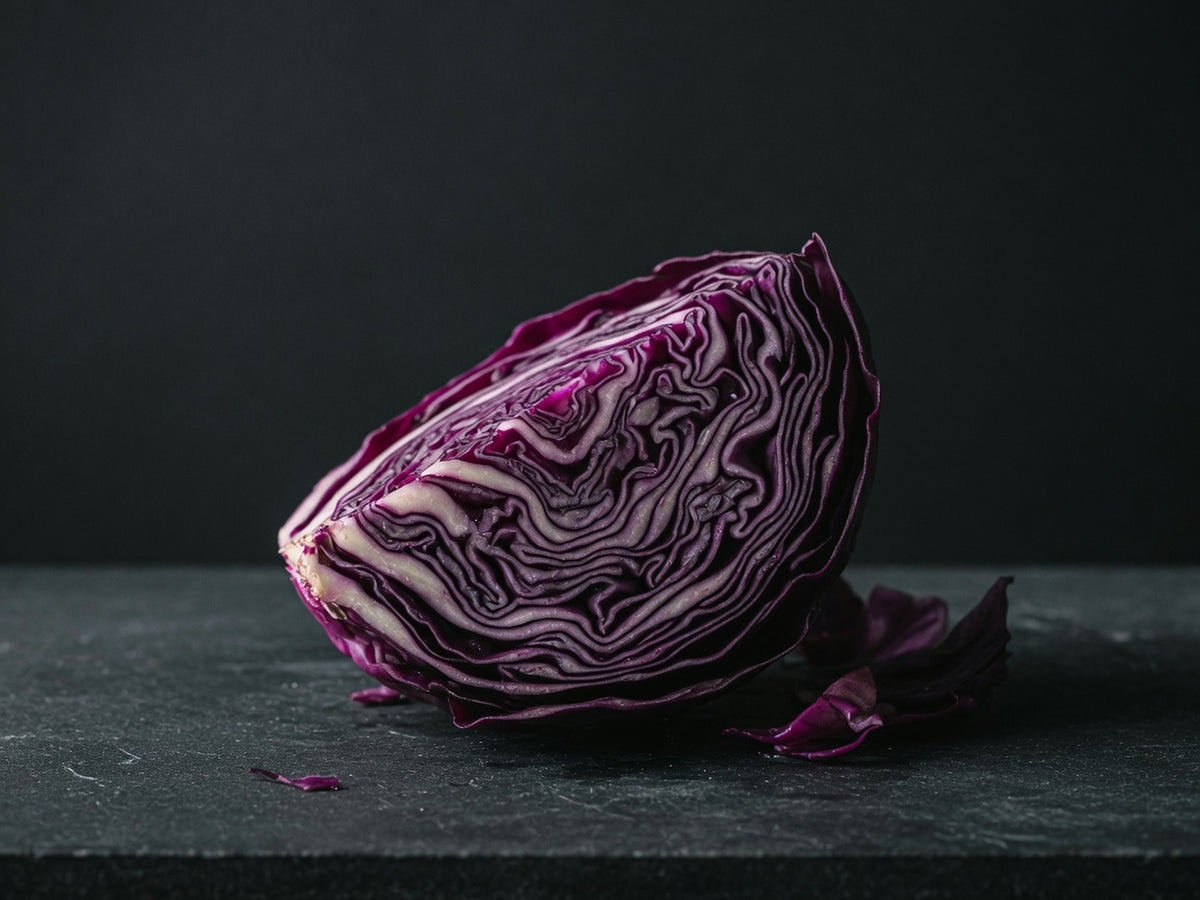 A wedge of raw red cabbage, cut to show tight purple concentric leaves.