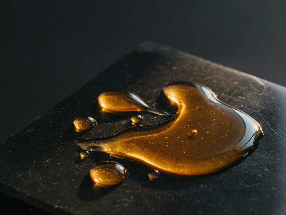 A pool of golden amber fish oil catching a warm highlight.
