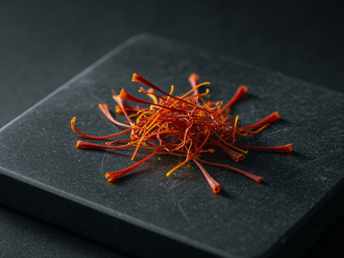 A small tangle of crimson-orange saffron stigmas, thread-like and translucent.